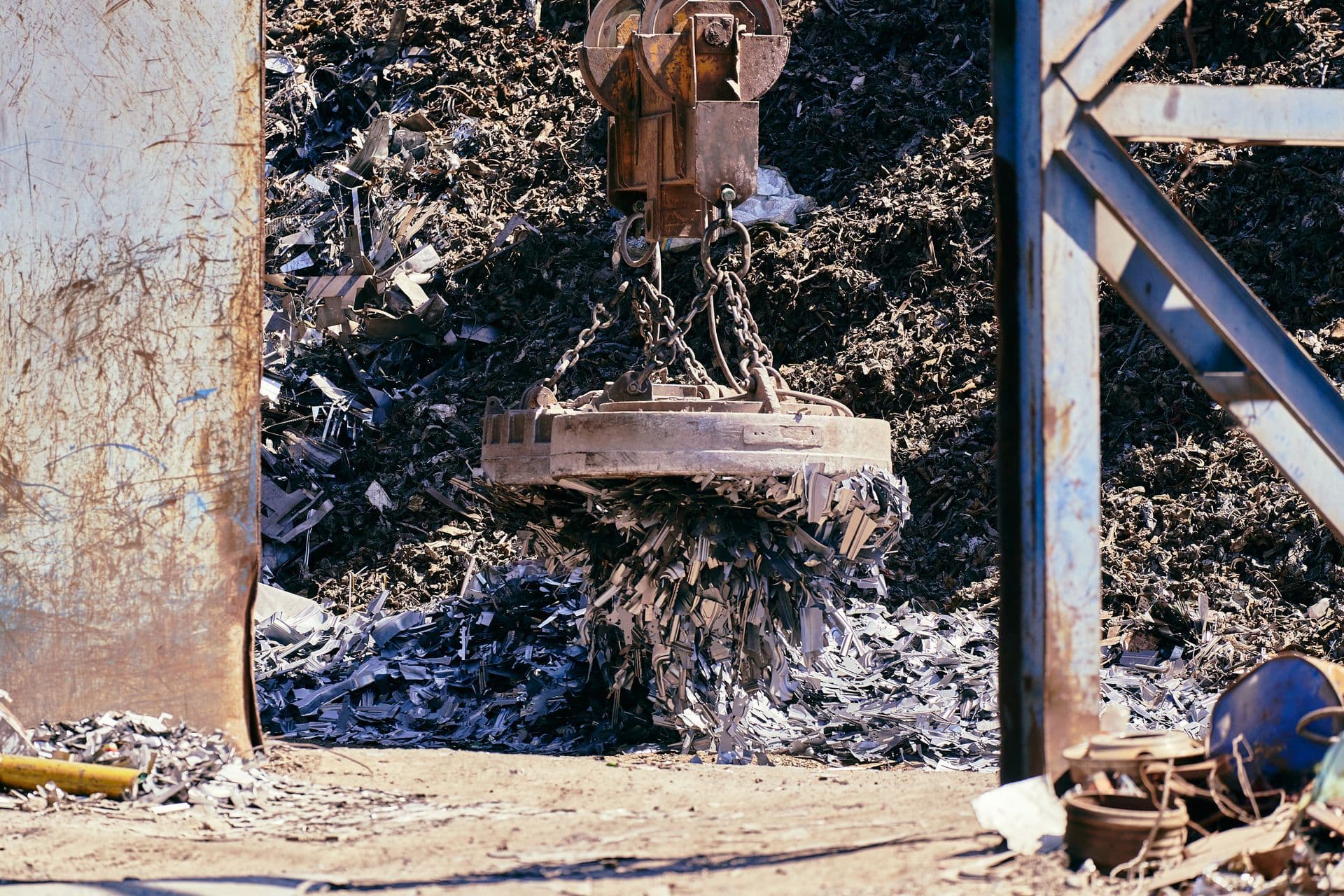 Magnet crane lifting scrap metal in a recycling yard